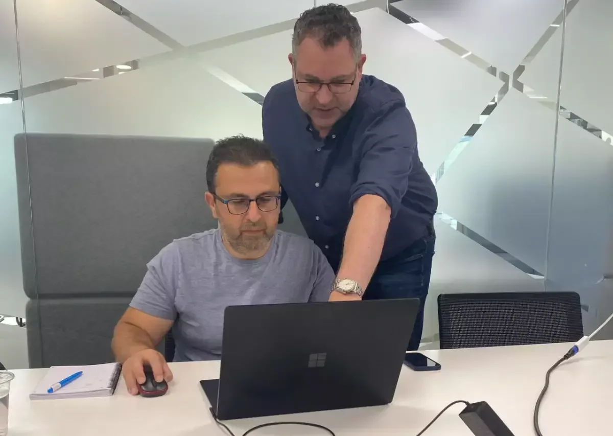 Trainer working side-by-side with a business leader during a hands-on AI training session.